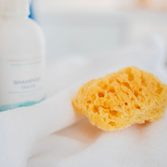 Spugna marina naturale su asciugamano bianco, ideale per pelli sensibili e neonati, Made in Italy